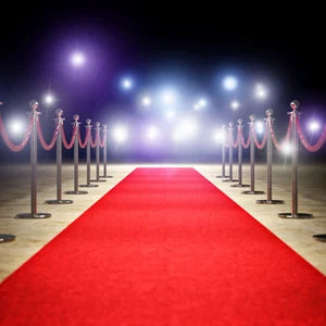 Gold stanchions arranged along a red carpet runner for an event